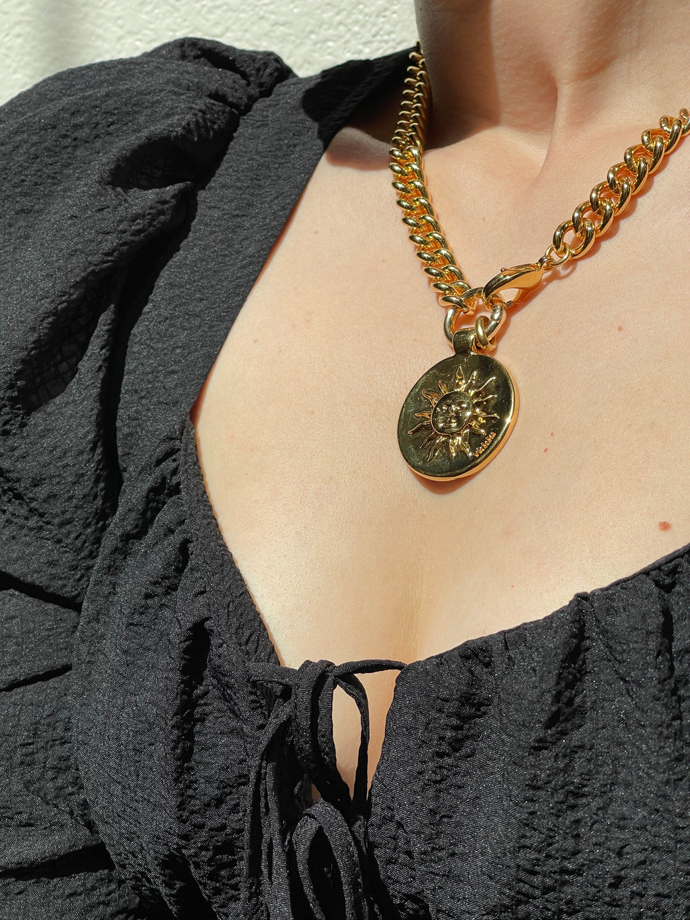 Gold plated curb chain necklace with one central double sided, compass and sun, coin